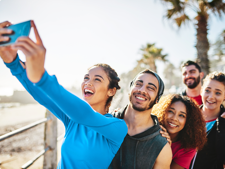 Data Clock - Free-range data binging Group of young people taking a selfie along a beach boardwalk
