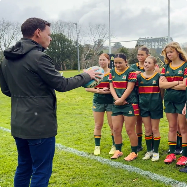 photo of paddy gower talking to a girls rugby team 
